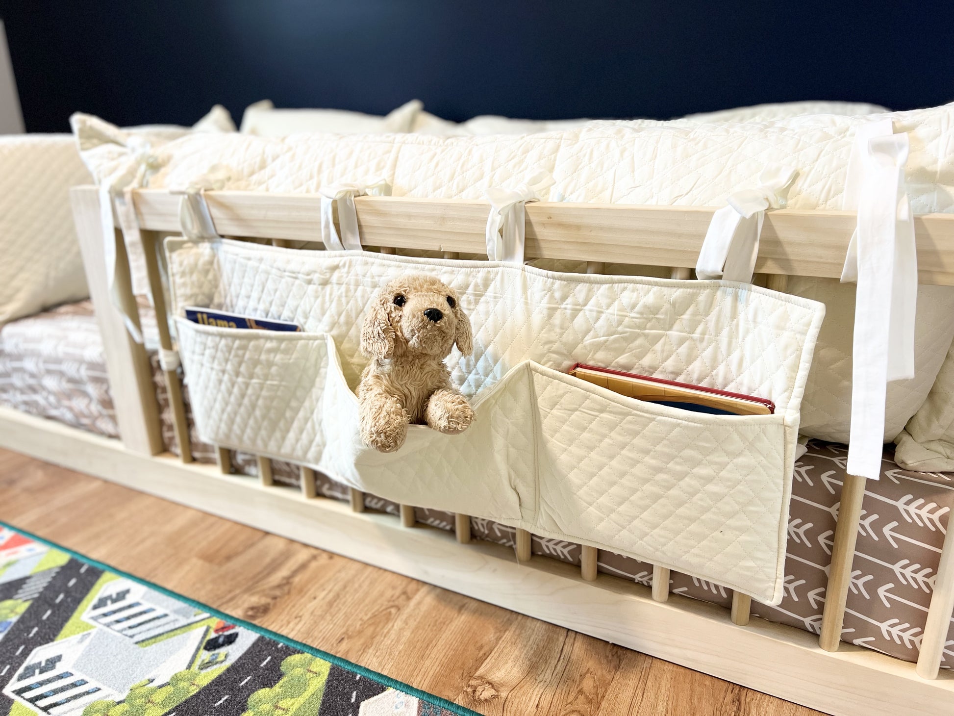 Diamond pillow cover and book organizer on toddler floor bed.