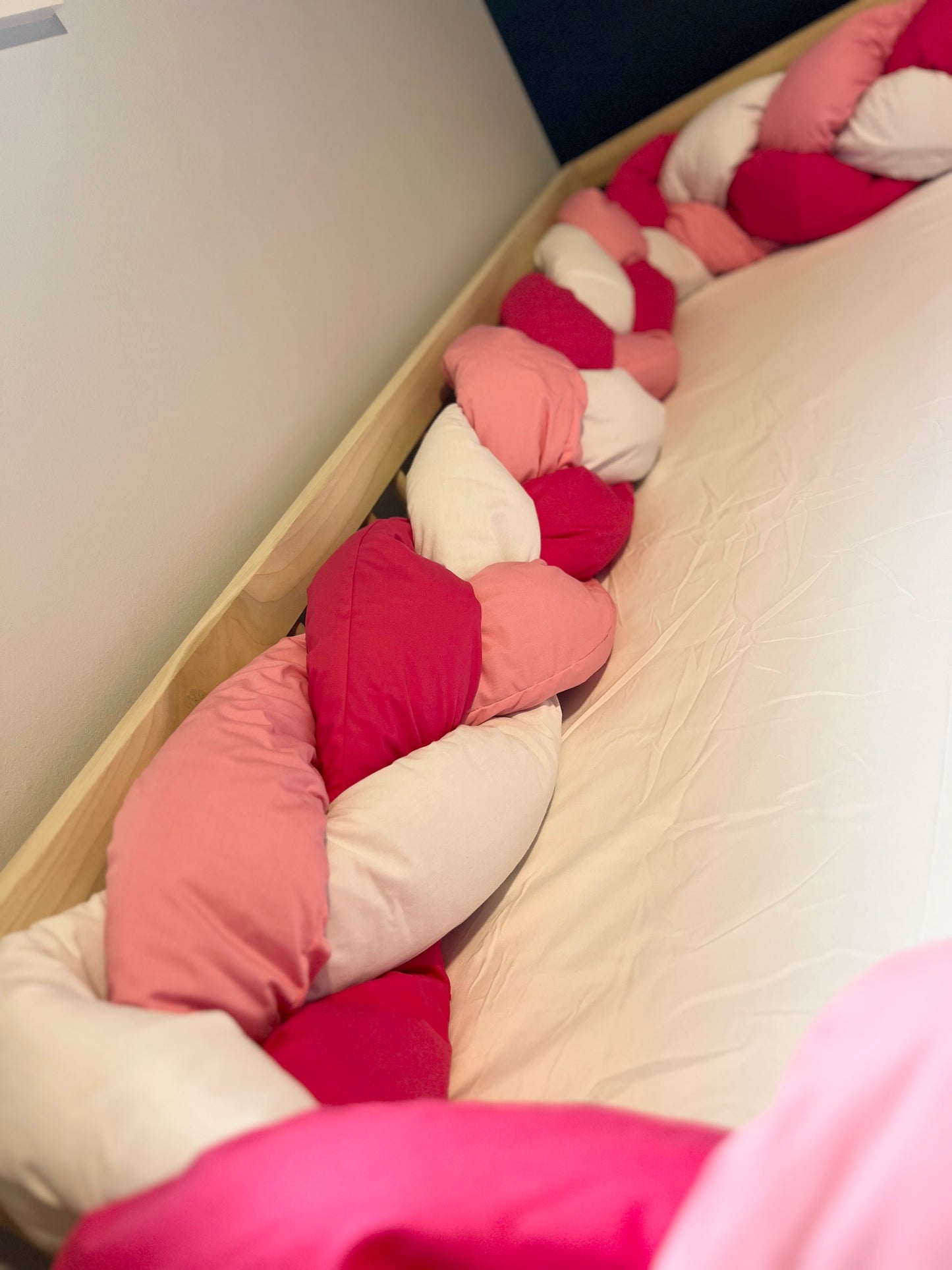 Tri color braided bumper on floor bed.